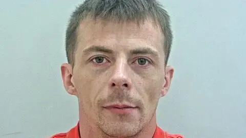 Mugshot of Daniel Robinson in an orange top