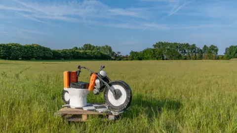 Sienna Anderson This toilet is in the middle of a field. It's designed like a motorbike, the toilet seat in place of the actual seat.