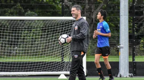 Gavin Step leads a kids training session on a football pitch
