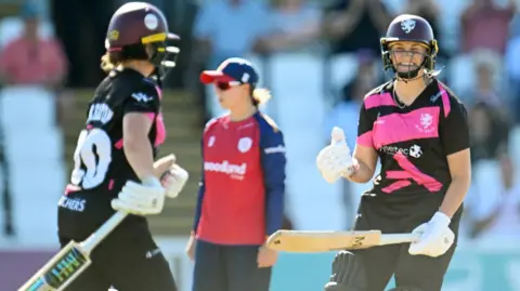 Chloe Skelton and a smiling Alex Griffiths celebrate Somerset's victory over Essex