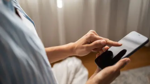Getty Images Woman holding a smartphone 