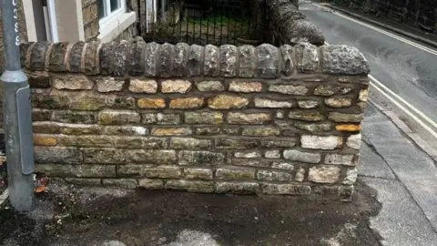 Supplied A garden wall with different shaped and coloured bricks. 