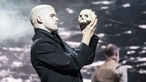 Actor Ralph Davis holds a skull aloft in the Royal Shakespeare Company's performance of Hamlet. 