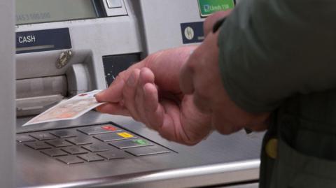 A person withdrawing cash