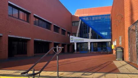 The front of Hartlepool Borough Council Civic Centre, a brick building with a blue frontage.