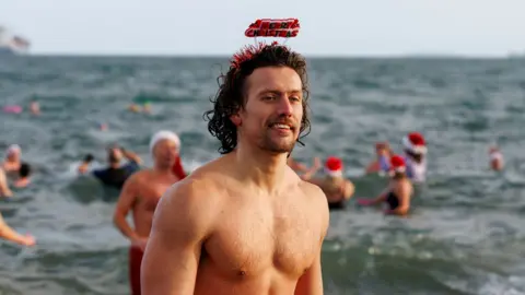 People taking part in the annual Christmas Eve swim at Helen's Bay, Co. Down, in aid of local charities.