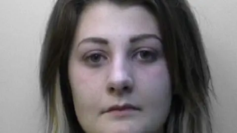 Sussex Police A custody photo of a woman with long brown hair