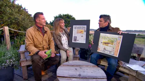 BBC Studios Three TV presenters sit outside on benches at a nature reserve. They are smiling and talking. Packham, on the left, has short dark hair and wears a light brown coat and he is holding a green television cue card. Strachan, centre, has short blonde hair and is wearing a grey jacket with a white blouse, and grey trousers. Another man, Martin Hughes-Games, on the right, has short dark grey hair and wears a brown coat with blue jeans.