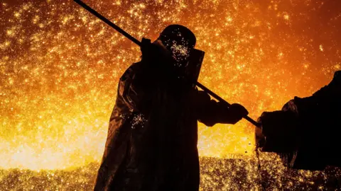 Getty Images Cast House operator Martin Rees changes the nozzle on a clay gun in Blast Furnace number four at the Tata Steel Port Talbot integrated iron and steel works in south Wales on 15 August, 2023