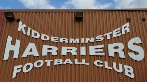 Shutterstock A sign on the exterior of Aggborough Stadium reads 'Kidderminster Harriers Football Club' in white font