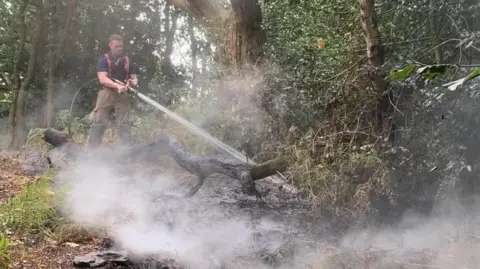 Leicestershire Fire and Rescue Service Firefighter tackling a blaze in a woodland