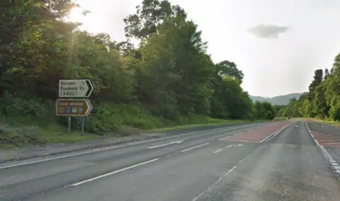 An empty dual carriageway with a road sign for Dunkeld and Birnam