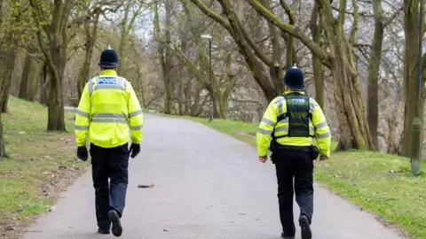 Nottinghamshire Police Two police officers in uniform patrol a park 