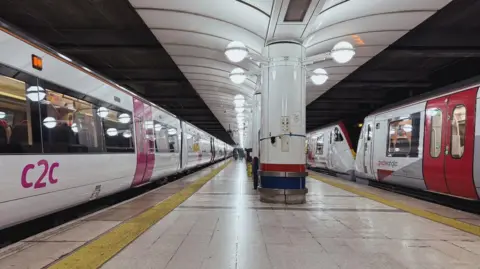 A c2c class 357 train and a Greater Anglia class 720 train at London Liverpool Street station, with a platform separating the two trains.