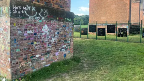 The column of brick-built Twemlow Viaduct, covered in graffiti about Harry Styles, and the blackboards and fence set up nearby to protect it