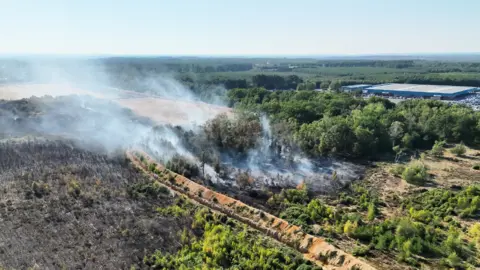 A drone shot of a wildfire on a sunny day
