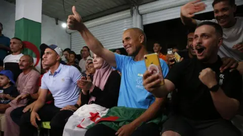 Hamza Zait / Getty Images An image of people in  Imane Khelif's village Biban Mesbah celebrating her victory in the women's 66kg semi-final boxing match at the Olympics in Paris - Tuesday 6 August 2024