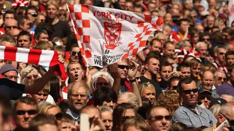 Getty Images A crowd of people with someone waving a York City flag.