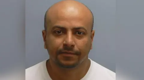 A handout photo issued by Hampshire Police of Anwar Ashraf. He is looking at the camera and wearing a white shirt.