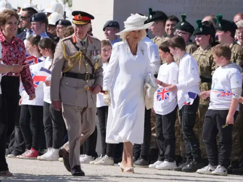 GARETH FULLER/AFP King Charles III and Queen Camilla are welcomed by British cadets and French primary schoolchildren as they arrived for the Royal British Legion's commemorative event.