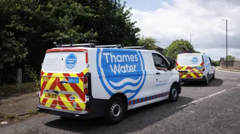 Two vans parked on the roadside with 'Thames Water' written prominently on the side.