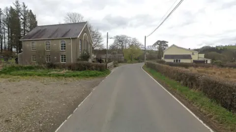 Google Maps Road near Caer Salem Baptist Chapel. The chapel is visible and trees are in the background. 