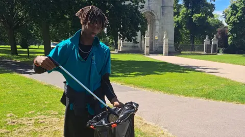 Supplied Boy picking litter