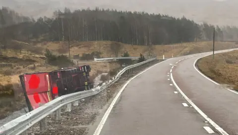 Bear NW Trunk Roads A lorry on its side by the road in wet conditions