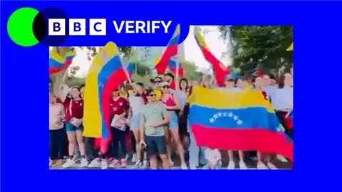 An image of people in the US holding a Venezuela flag. There is a BBC Verify logo added