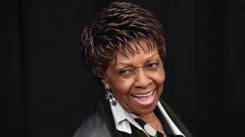 Getty Images A smiling Cissy Houston photographed with a black backdrop. 