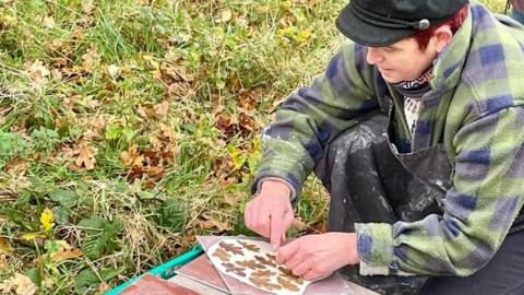 Ruth Gibson pressing fallen leaves into clay