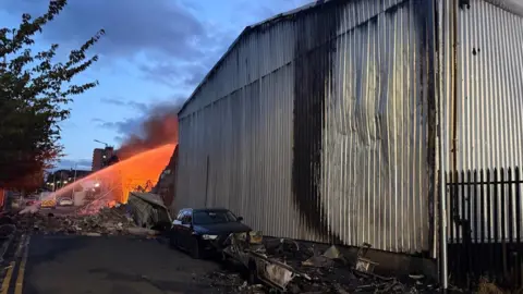 A fire crew tackles a fire at an industrial unit