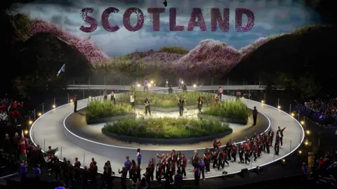 Athletes file past the garden on stage