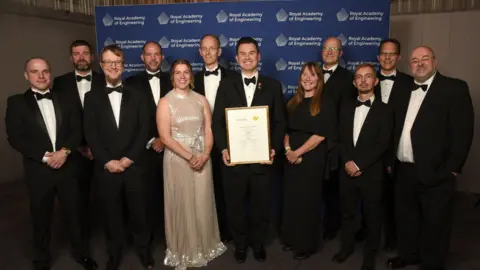 The OrganOx team at the Royal Academy of Engineering award ceremony, with Prof Constantin Coussios in the middle, holding the award. The team is smiling for the camera. 