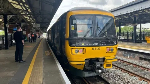 A local train service waiting at a platform at Westbury, Wiltshire