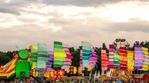 Hello Content Colourful flags and banners billow in sunlight at Camp Bestival in Shropshire