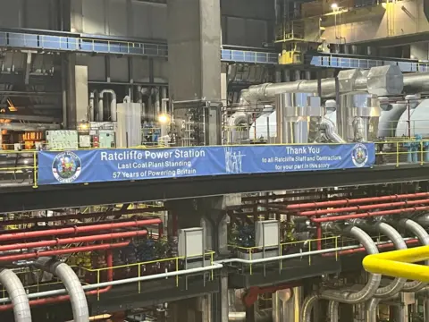 A blue sign commemorating Ratcliffe Power Station and thanking staff is displayed. 