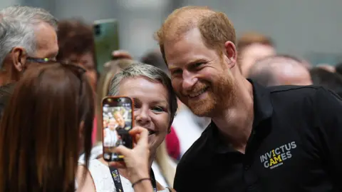 PA Media Prince Harry has is photo taken with a woman.