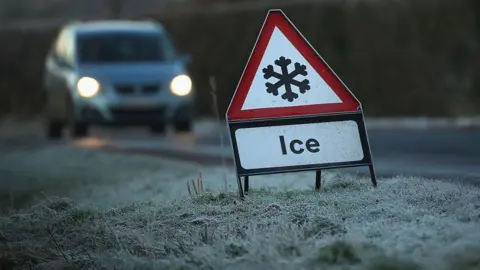 Getty Images A road sign with a snowflake icon. There is a car driving on the road.
