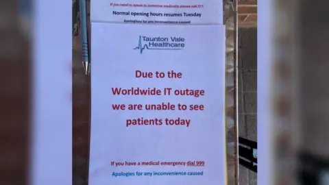 BBC A notice outside a GP surgery saying patients cannot be seen due to the outage