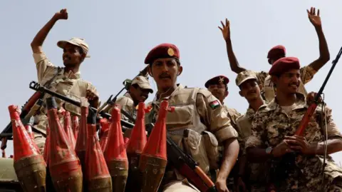 Reuters Sudan's paramilitary Rapid Support Forces (RSF) soldiers greet people as they secure a site where their attends a meeting in Khartoum in June 2019. 