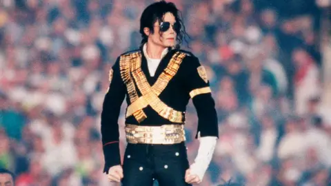 Getty Images Singer Michael Jackson, wearing a black and gold suit, performs at the 1993 Pasadena, California, Superbowl XXVII halftime show. 