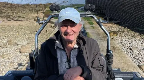 Man sat on tractor near the coast 