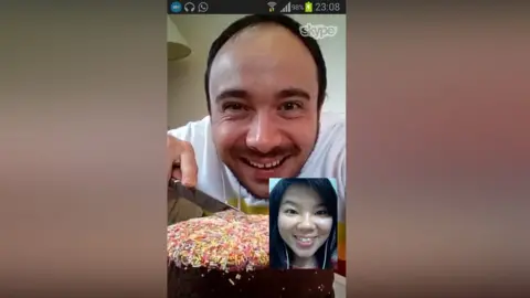 Weng and Owen Williams A man and a woman celebrating a birthday over Skype, with the man cutting a birthday cake.
