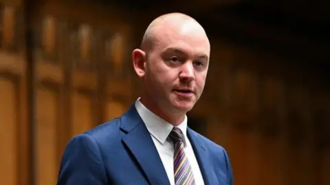 An image of the Fylde MP Andrew Snowden speaking in the House of Commons. He is wearing a blue suit, white shirt and multi-coloured tie.