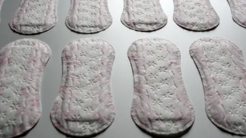 Getty Images Pink and white sanitary towels laid on a white or grey surface.