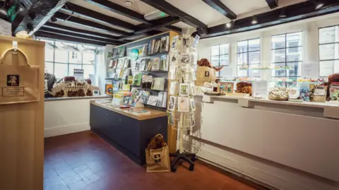 Caroline Bridges Photography The shop inside the heritage centre where many items for sale are on display on shelves and in a window. 