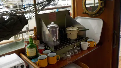 Jon Fieldhouse A 1960s cooker surrounded by cups and pans 