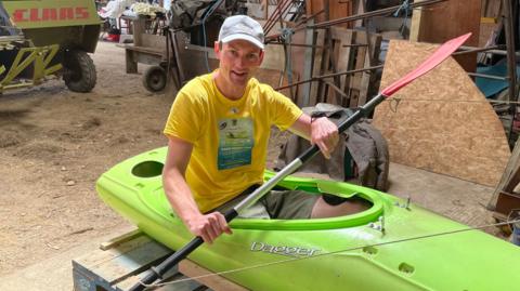 Brad sits in a training machine made from a cut off kayak 