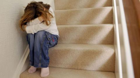 Girl hiding face on stairs